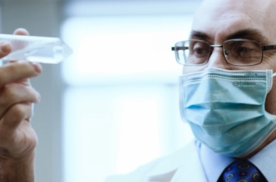 Infectious disease expert Dr. Drew Weissman holding and looking at test tube